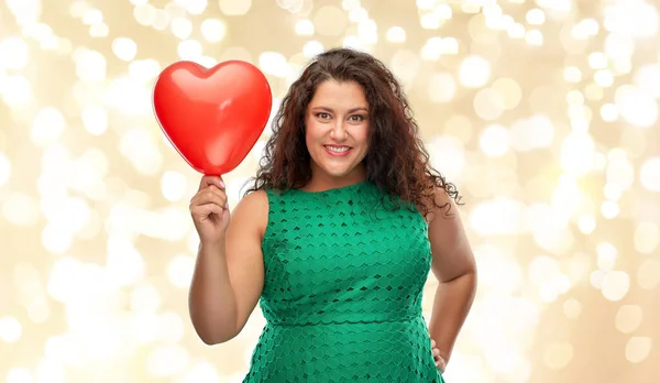 Mulher feliz segurando balão em forma de coração vermelho — Fotografia de Stock