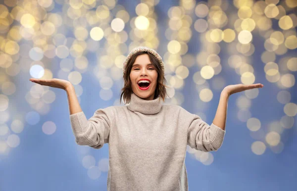 Mujer en invierno sombrero sosteniendo algo en Navidad —  Fotos de Stock