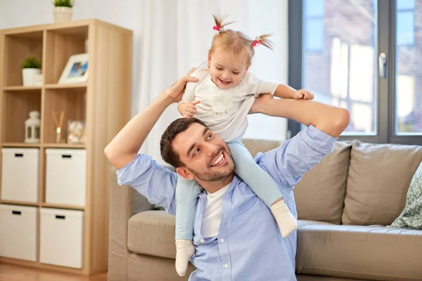Father riding little baby daughter on neck at home — Stock Photo, Image