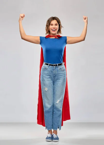 Szczęśliwy kobieta w czerwony superhero peleryna pokazując moc — Zdjęcie stockowe