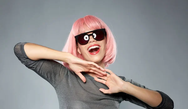 Mulher feliz em peruca rosa e óculos de sol pretos — Fotografia de Stock
