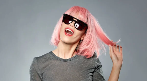Glückliche Frau mit rosa Perücke und schwarzer Sonnenbrille — Stockfoto