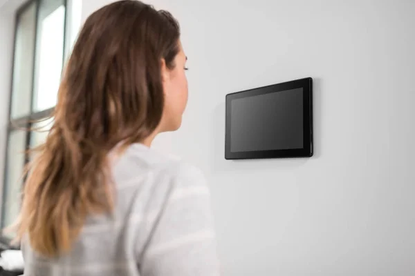 Vrouw op zoek naar tablet computer bij smart home — Stockfoto