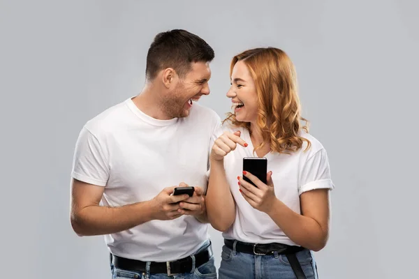 스마트폰이 달린 흰색 티셔츠를 입고 행복 한 커플 — 스톡 사진