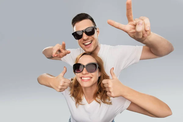 Feliz pareja en gafas de sol mostrando paz — Foto de Stock
