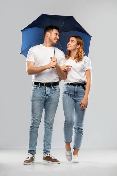 Gelukkig paar in witte t-shirts met paraplu — Stockfoto