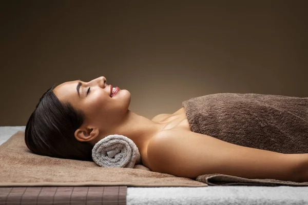 Ung kvinna liggande på spa eller massagesalong — Stockfoto