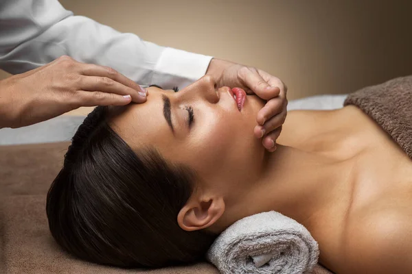 Kobieta mająca masaż twarzy i głowy w spa — Zdjęcie stockowe