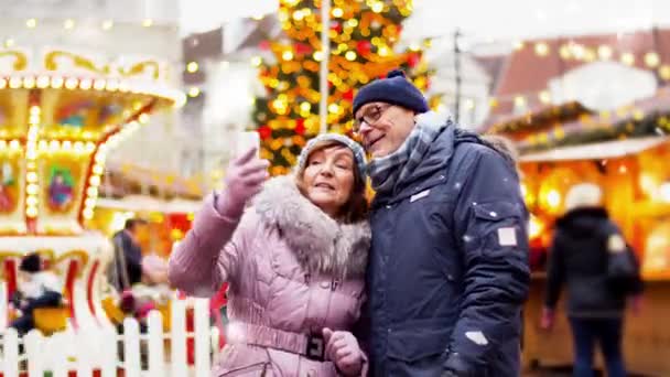 Senior couple taking selfie at christmas market — Stock Video