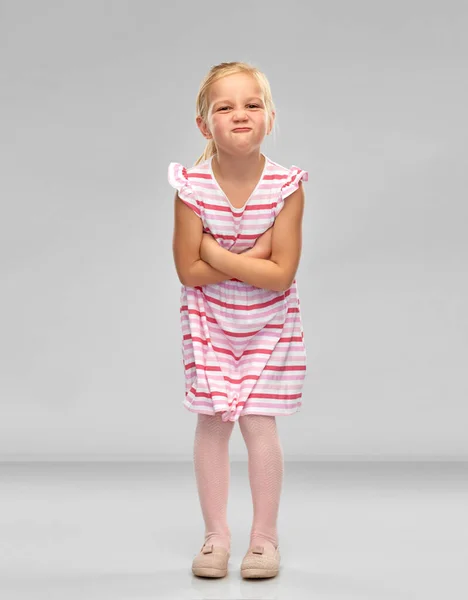 Missnöjd liten flicka med korsade armar sura — Stockfoto