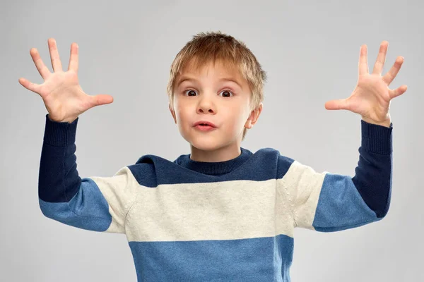 Portrét malého chlapce v pruhovaném svetru hrající — Stock fotografie