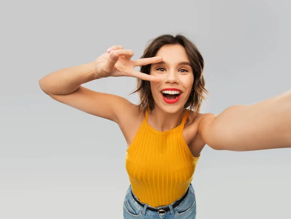 Mulher feliz tomando selfie e mostrando sinal de paz — Fotografia de Stock