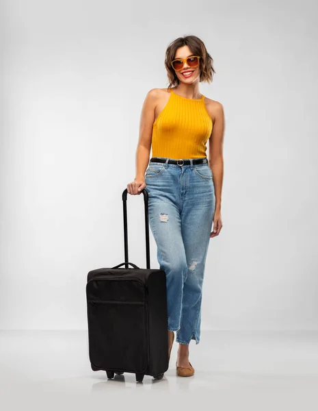 Mujer joven feliz en gafas de sol con bolsa de viaje —  Fotos de Stock