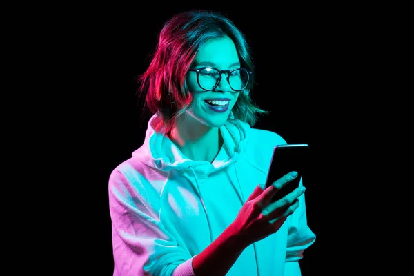 Woman wearing hoodie in neon lights over black — Stock Photo, Image