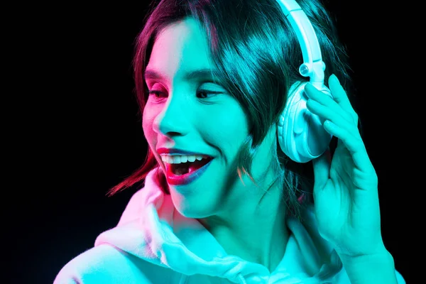 Mujer en auriculares escuchando música en neón —  Fotos de Stock