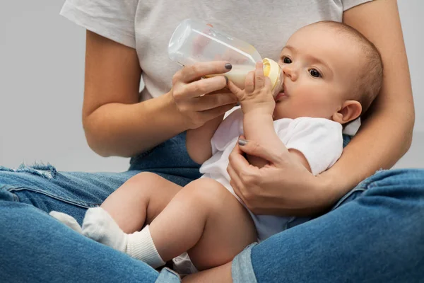 Close up of mother feeding baby with milk formula — Stock Photo, Image