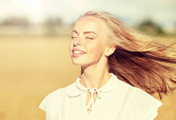 Lachende jonge vrouw in wit op granen veld — Stockfoto