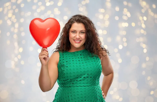 Mulher feliz segurando balão em forma de coração vermelho — Fotografia de Stock