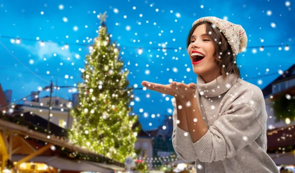 Şapkalı kadın Noel pazarında hava öpücüğü yolluyor. — Stok fotoğraf