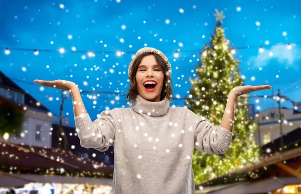 Gelukkig vrouw in hoed op kerstmarkt — Stockfoto