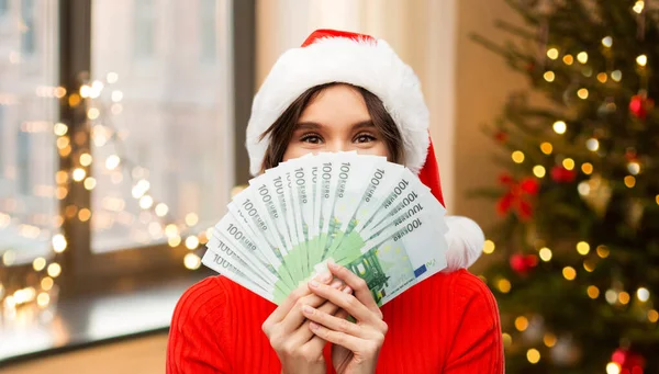 Ευτυχισμένη γυναίκα με καπέλο Σάντα με χρήματα τα Χριστούγεννα — Φωτογραφία Αρχείου