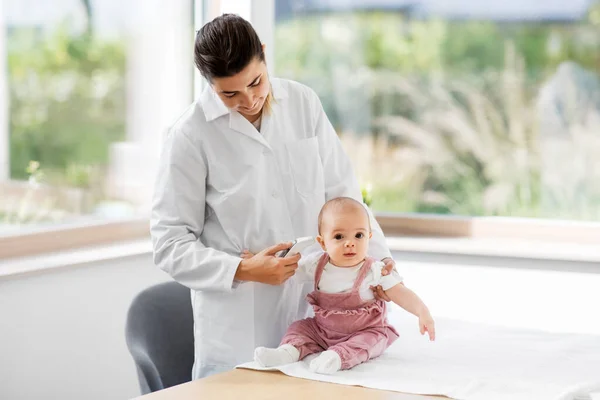 Doctor with thermometer measures baby temperature — Stock Photo, Image