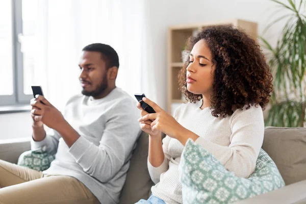 Africano casal americano com smartphone em casa — Fotografia de Stock