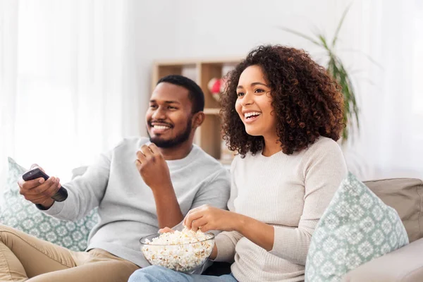 Africký pár s popcornem sledování televize doma — Stock fotografie