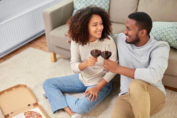 Casal feliz com vinho e pizza takeaway em casa — Fotografia de Stock