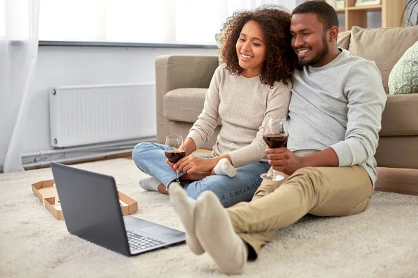 집에서 레드 와인을 마시는 랩탑 컴퓨터를 가진 행복 한 커플 — 스톡 사진