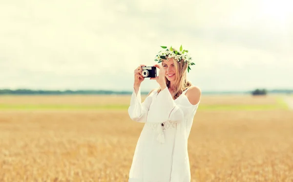 Szczęśliwa kobieta z kamerą filmową w wieńcu kwiatów — Zdjęcie stockowe