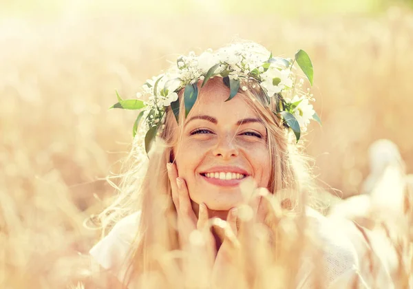 Gelukkig vrouw in krans van bloemen op graan veld — Stockfoto