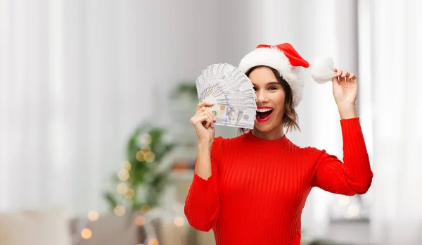 サンタ・ハットの幸せな女性クリスマスにお金を持って — ストック写真