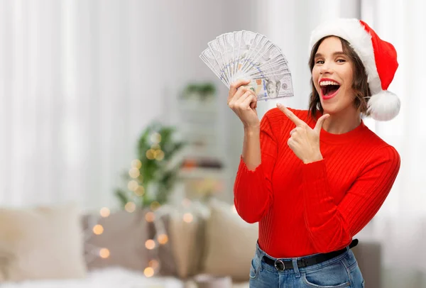Lycklig kvinna i tomte hatt med pengar på jul — Stockfoto