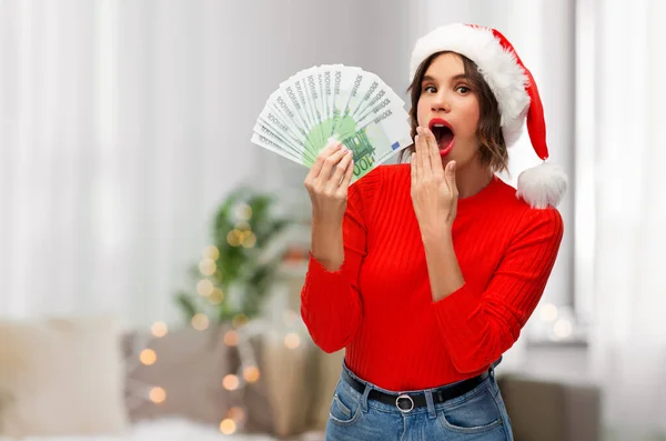 Donna in cappello da Babbo Natale con soldi a Natale — Foto Stock