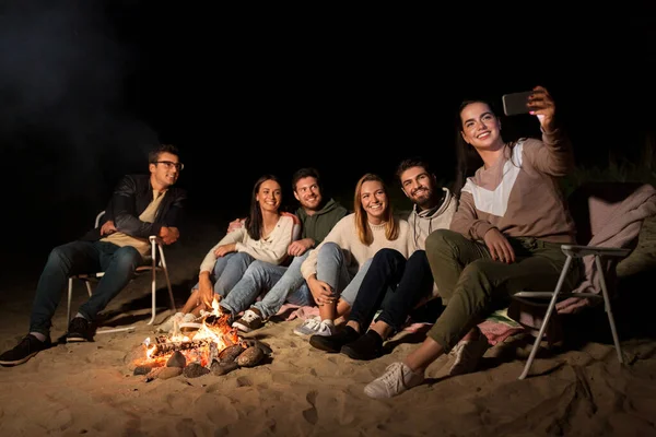 Amis heureux prendre selfie au feu de camp sur la plage — Photo