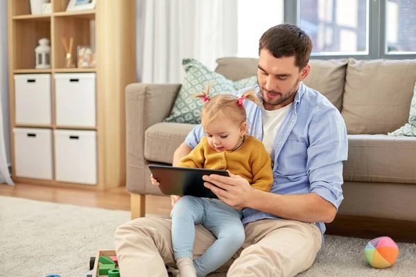 父亲和婴孩女儿用平板电脑在家 — 图库照片