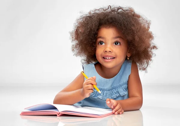 Heureuse petite afro-américaine fille avec carnet de croquis — Photo