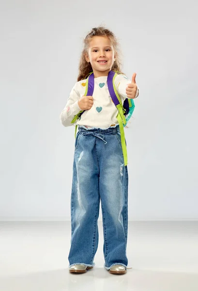 Heureuse fille avec école sac à dos montrant pouces vers le haut — Photo