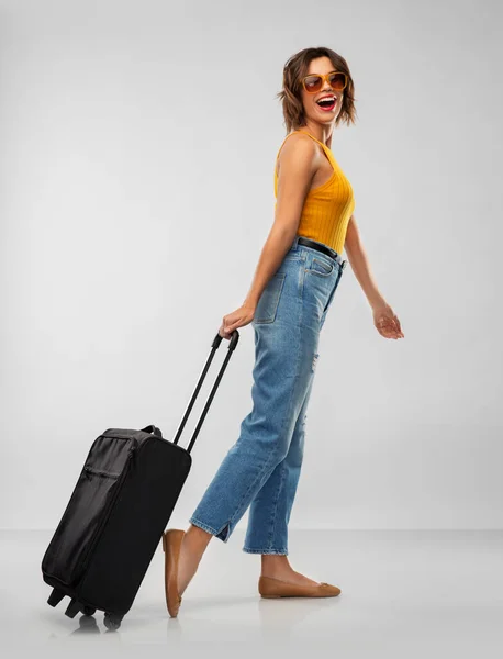 यात्रा बैग के साथ धूप के चश्मे में खुश युवा महिला — स्टॉक फ़ोटो, इमेज