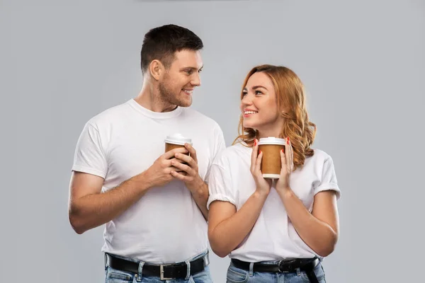 Portrait of happy couple with takeaway coffee cups — Stock Photo, Image