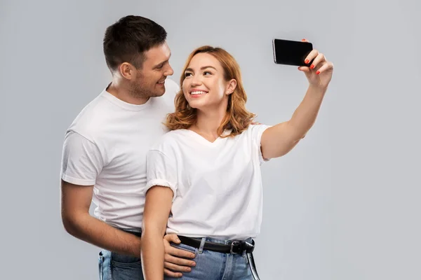 Felice coppia in bianco t-shirt prendendo selfie — Foto Stock