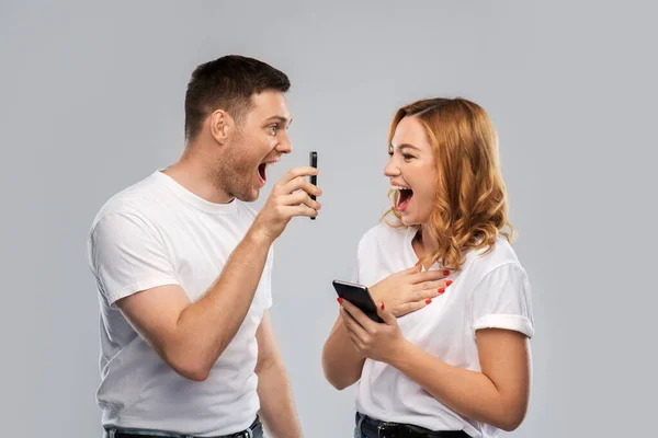 Boldog pár fehér pólóban okostelefonnal — Stock Fotó