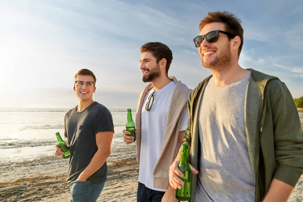 Νέοι άνδρες με μη αλκοολούχα μπύρα περπάτημα στην παραλία Φωτογραφία Αρχείου