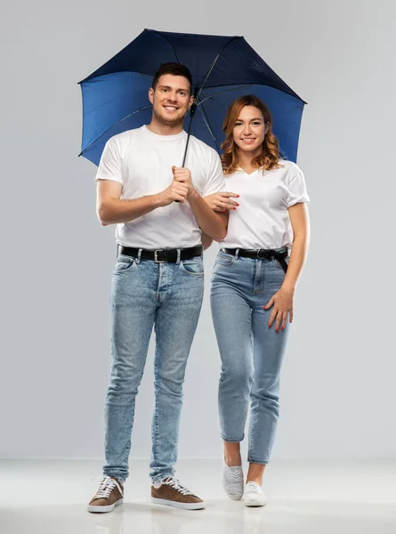 Šťastný pár v bílých tričkách s deštníkem — Stock fotografie
