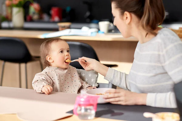 행복 한 어머니 가집에서 아기에게 순한 음식을 먹이는 모습 — 스톡 사진
