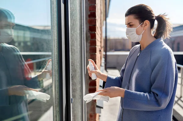 Mujer en la manija de la puerta de limpieza de máscara con desinfectar — Foto de Stock