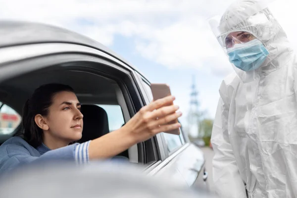 Mujer en coche mostrando fohe al trabajador de la salud —  Fotos de Stock