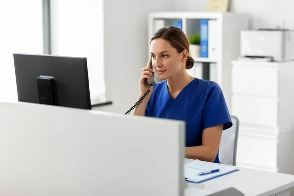 Médecin avec ordinateur appelant au téléphone à l'hôpital — Photo