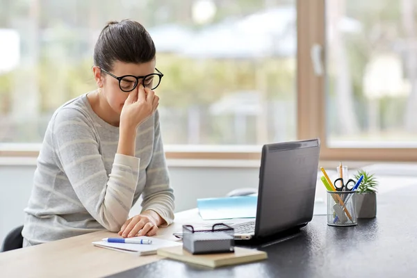 Vermoeide vrouw met laptop werken op kantoor — Stockfoto